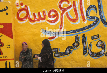 Ägypten Luxor Frauen chatten vor bemalten Wand Stockfoto