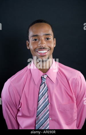 Porträt eines jungen lächelnd 18-jährige Afroamerikaner Mannes trägt ein rosa Hemd und gestreifter Krawatte Stockfoto