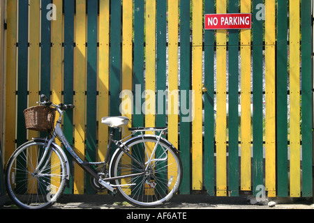 Damen Fahrrad gelehnt gegen einen bunten Tor in Carlingford, County Louth, Irland Stockfoto