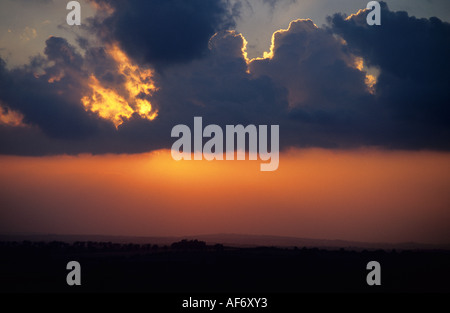 Die untergehende Sonne bricht durch die Wolken über der Landschaft Oxfordshire Stockfoto