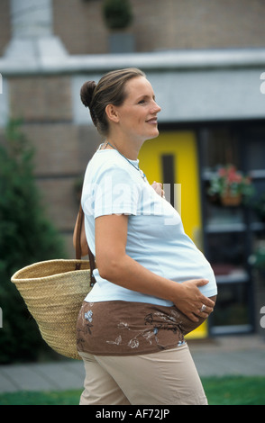 Schwangere Frau gehen im freien Stockfoto