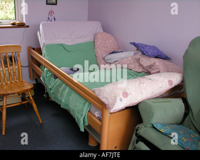 Behinderte Person s verstellbares Bett mit Glocke befestigt für Beschwörung Aufmerksamkeit der Pflegeperson Helfer Mutter Vater Stockfoto