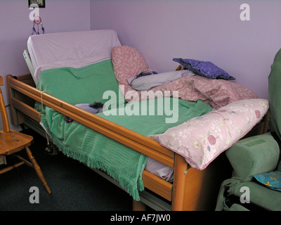 Behinderte Person s verstellbares Bett mit Glocke befestigt für Beschwörung Aufmerksamkeit der Pflegeperson Helfer Mutter Vater Stockfoto