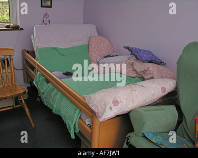 Behinderte Person s verstellbares Bett mit Glocke befestigt für Beschwörung Aufmerksamkeit der Pflegeperson Helfer Mutter Vater Stockfoto