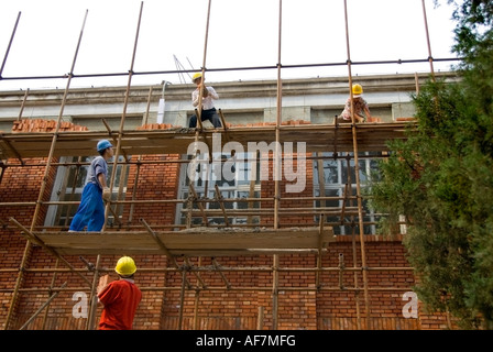 Peking, CHINA, außerhalb Gruppe von "Bauarbeiter" Standort Installation "Red Brick" Fassade auf alten Industriegebäude, Arbeiter auf der Baustelle Stockfoto