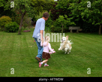 Grossvater Enkelin & Hund Spaß im Garten in Surrey England Stockfoto