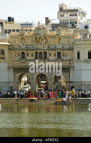 Vertikale Weitwinkel von eine Gruppe von Indianern, traditionell gekleidet auf einer Hochzeitsparty auf den Ghats in der Sonne. Stockfoto