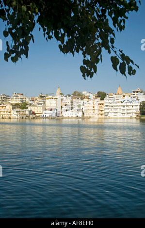 Vertikale Weitwinkel über das Wasser des Lake Pichola, die weiß getünchten Häuser der alten Stadt von Udaipur vor blauem Himmel Stockfoto