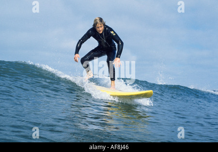 Wasser Schuss der Surfer auf einer Welle abnehmen, so wie er auf seinem Surfbrett Croyde Bay Devon England aufsteht hautnah Stockfoto