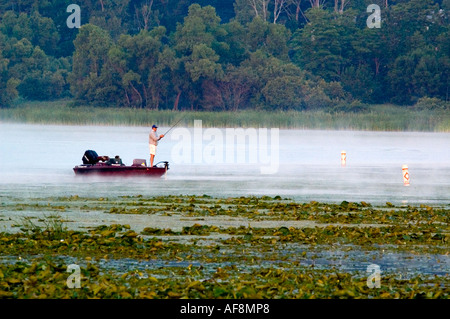 Fischer versucht sein Glück in den frühen Morgenstunden auf einem Nebel bedeckt White Lake in der Nähe von Montague MI Stockfoto