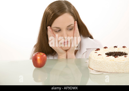 Frau mit Apfel und Kuchen, die Hände auf Wange Stockfoto