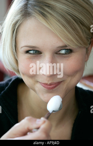 Junge blonde Frau genießt die schaumige Creme ihr cappucchino Stockfoto