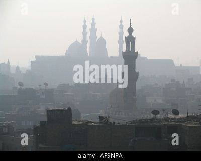 Blick auf kleine Moschee in schlechte Wohngegend und die Zitadelle mit der Mohammed Ali Mosque unter der Smog in Kairo, Motorradfahrt ausgeblendet Stockfoto