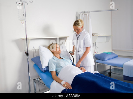 Krankenschwester Überprüfung Blutdruck der Patientin Stockfoto