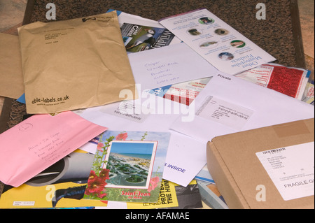 ein Berg von Post liegen auf eine Fußmatte, die in den Briefkasten geschoben worden Stockfoto