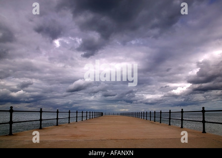 Gewitterwolken bilden über eine leere pier Stockfoto