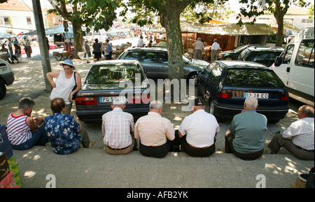 Eine Gruppe älterer Männer sitzt im Schatten in einer Linie, der Markt, Viana do castelo, Minho, Nordportugal Stockfoto