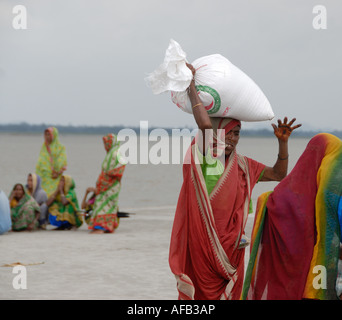 Flut betroffenen Norden Bangladesch, Juni 2007.People mit Notfall Haushaltspackungen Distributied durch Rothalbmond-Gesellschaft. Stockfoto