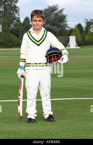 Kleiner Junge in voller Cricket weiß Kit mit Helm Fledermaus Handschuhe Stockfoto