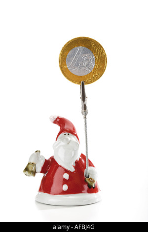 Santa Claus Figur hält Euro-Münze Stockfoto