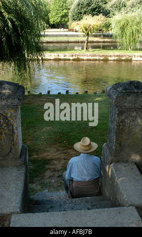 französischer Mann sitzt auf Schritt vom Fluss Dronne in Brantome Dordogne Frankreich Stockfoto