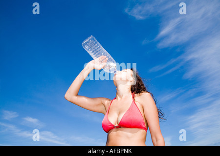 Junge Frau aus Flasche Wasser trinken Stockfoto