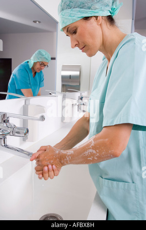 Weibliche Chirurg und Chirurgen, die Hände zu waschen Stockfoto
