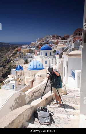 Fotografen mit Großformat-Kamera Captutre Mittag Blick auf die schöne Stadt Oia, Santorini, Griechenland Stockfoto