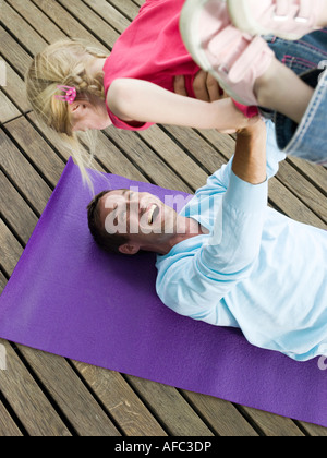 Ausgleichende Tochter Vater auf Füßen Stockfoto