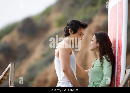 Paar sprechen neben roten Surfbrett Stockfoto