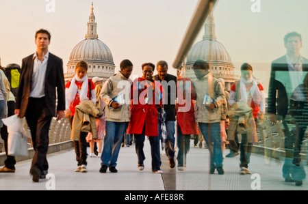 Sunset Glow Beleuchtung Menschen Millennium Brücke weg von St. Paul in Richtung Bankside London Spaß glücklich drängeln Stockfoto