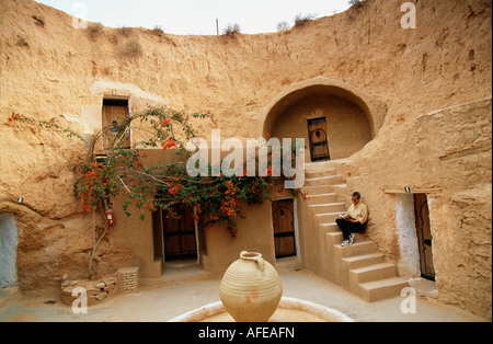 Tunesien Matmata, Sahara Wüste, Touristen sitzen auf der Treppe der Höhle, die als Hotel, bevor Sie als Haus verwendet wird Stockfoto