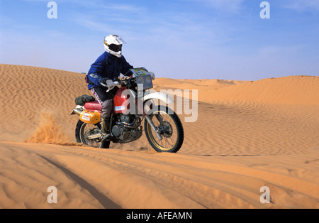 Tunesien, Ksar Ghilane, Tourist auf dem Motorrad in der Wüste Sahara Stockfoto