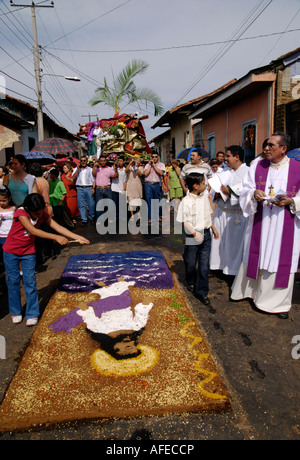 Anhänger tragen ein Modell von der Kreuzigung über einen Teppich von Sägemehl während einer Prozession der Semana Santa, Leon, Nicaragua Stockfoto