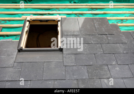 MONTAGE EIN VELUX-FENSTER AUF EINEM SCHIEFERDACH IM BAU ZEIGT DIE ATMUNGSAKTIVE ÜBERDACHUNG FILZ MIT HÖLZERNEN BATONS Stockfoto