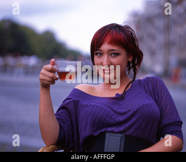 Schöne Holländerin Schlucke Tee in einem Café neben dem Kanal im Zentrum von Amsterdam. Stockfoto