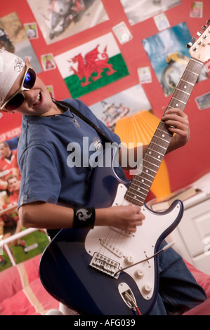 Junge, die Gitarre in seinem Schlafzimmer Stockfoto