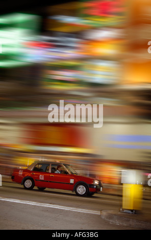 Hong Kong rotes Taxi in der Nacht mit hellen Motion blur Bckground. Wirkung in der Kamera erreicht. Stockfoto