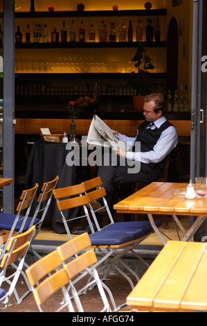 Mann liest Zeitung in ruhigen Café im Prenzlauer Berg in Berlin Stockfoto