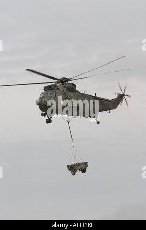 Royal Navy Sea King HC4 Commando Truppe tragen Angriff Hubschrauber mit underslung Fahrzeug Anhängelast Stockfoto