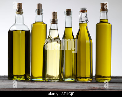 Verschiedene Olivenöle in Flaschen auf weißem Hintergrund Stockfoto