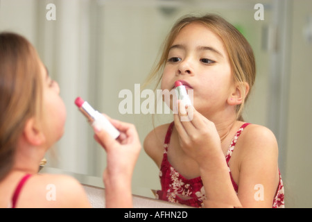 Zum ersten Mal versucht, auf Lippenstift vor dem Badezimmerspiegel lernen über Kosmetik und Schönheit Stockfoto