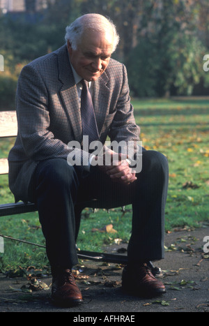 Alter Mann sitzt auf der Bank im park Stockfoto