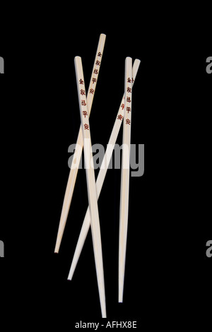 Zwei Paar Essstäbchen mit japanischen Zeichen auf schwarzem Hintergrund Stockfoto