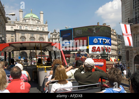 London an Bord Oberdeck öffnen Top-Tour-Bus mit Touristen Blick in Richtung Piccadilly Circus Eros & Werbung Horten Stockfoto