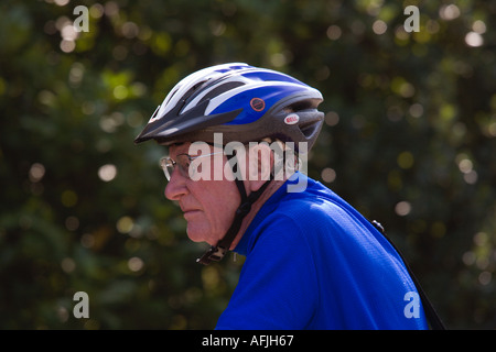 Ein Alter Rentner in vollem Umfang Radfahren Kleidung liegt im historischen Dorf von Dedham in Essex England Stockfoto
