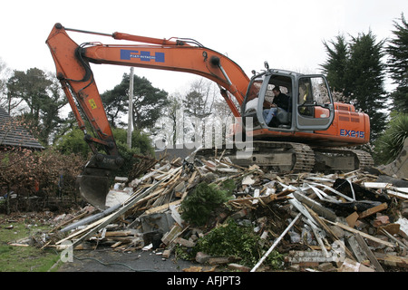 Treiber mit geöffneter Kabinentür von orange Fiat Hitachi JCB auf Baustelle Entfernen von abgerissenen alten Gebäude auf braune Feld Sanierung Website Stockfoto