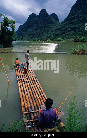 Yulong Fluss, Nr Yangshuo, Guangxi Provinz. Dorf jungen Fische aus einem Bambusfloß. Stockfoto