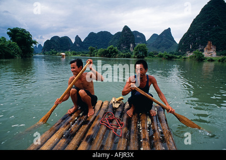 Yulong Fluss, Nr Yangshuo, Guangxi Provinz Schiffer Pol Bambus Flöße auf dem ruhigen Fluss Stockfoto