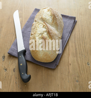 Knuspriges Weißbrot und Messer auf Leinen Serviette Stockfoto